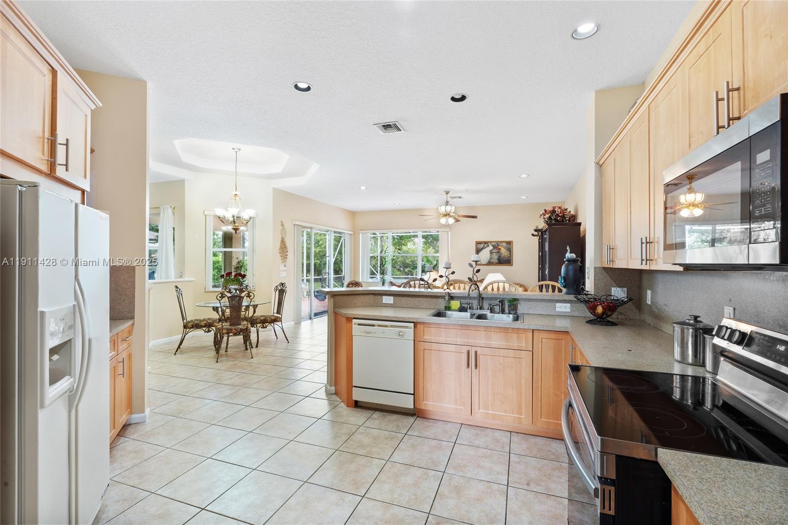 13875 Southwest 41st Street Davie, FL 33330 - Photo 22 of 62 a kitchen with stainless steel appliances granite countertop a refrigerator and a stove top oven