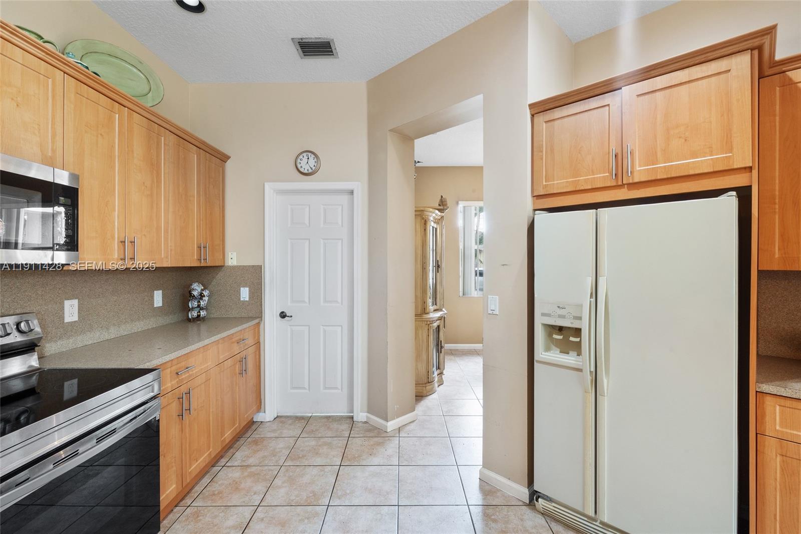 13875 Southwest 41st Street Davie, FL 33330 - Photo 23 of 62 a kitchen with a refrigerator a sink and cabinets