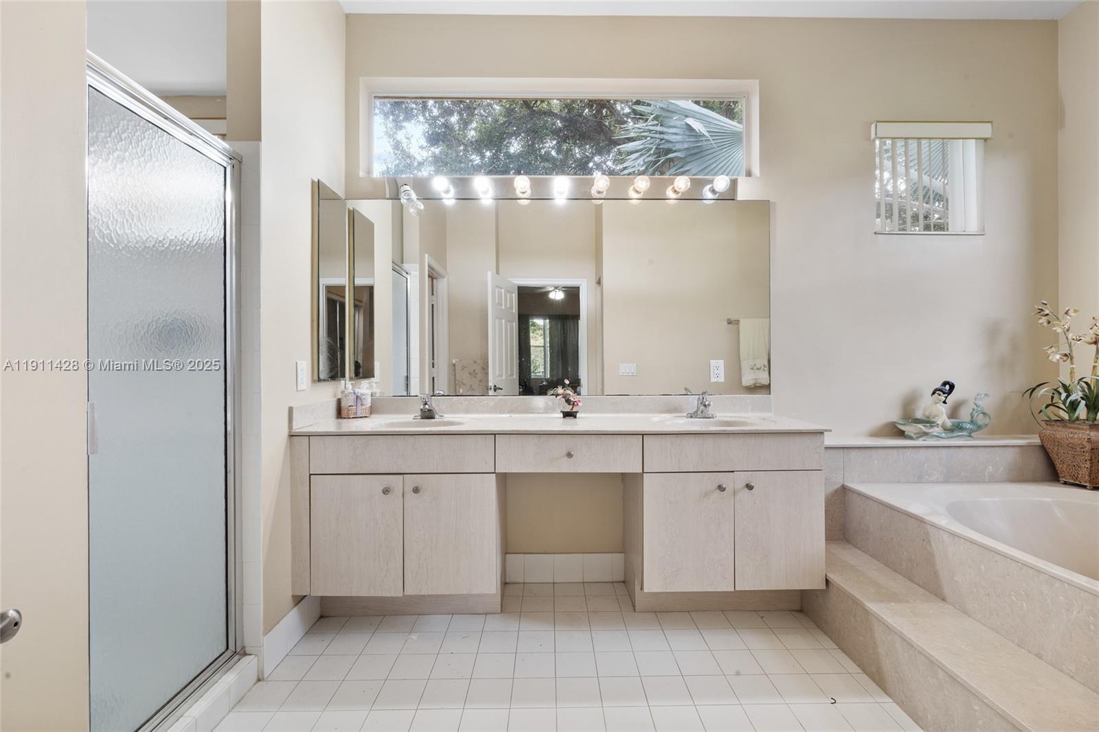 13875 Southwest 41st Street Davie, FL 33330 - Photo 26 of 62 a large bathroom with a double vanity sink a mirror and a bathtub