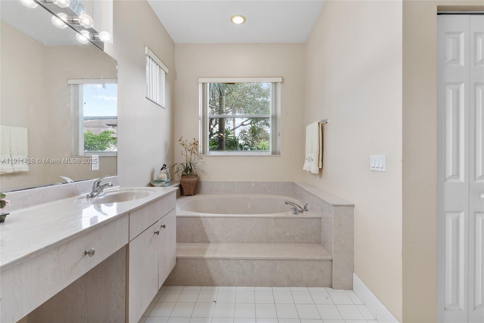 13875 Southwest 41st Street Davie, FL 33330 - Photo 27 of 62 a spacious bathroom with a tub sink and mirror