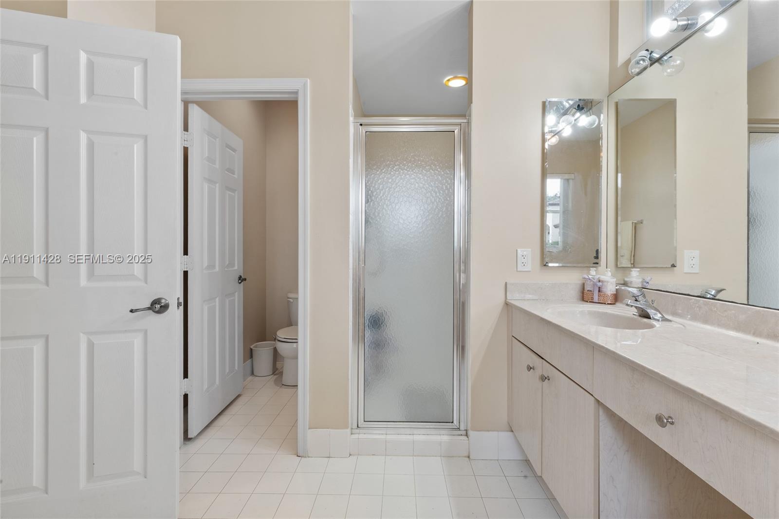 13875 Southwest 41st Street Davie, FL 33330 - Photo 28 of 62 a bathroom with a double vanity sink mirror and shower
