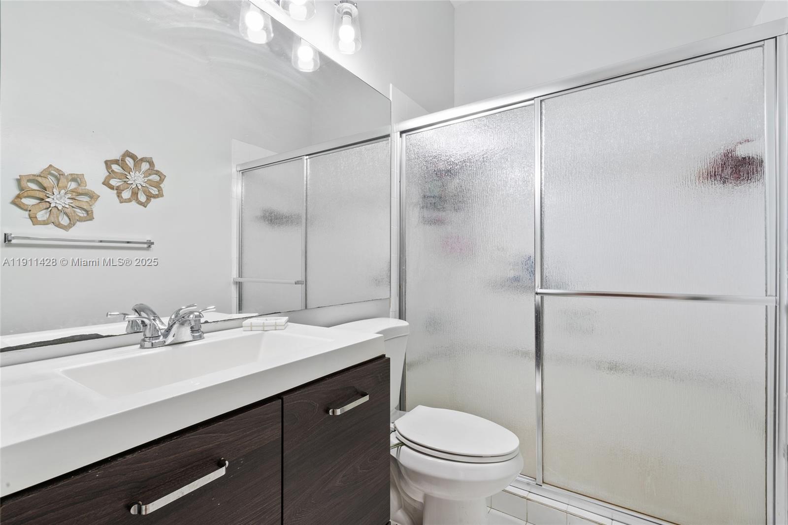 13875 Southwest 41st Street Davie, FL 33330 - Photo 31 of 62 a bathroom with a sink mirror vanity and toilet