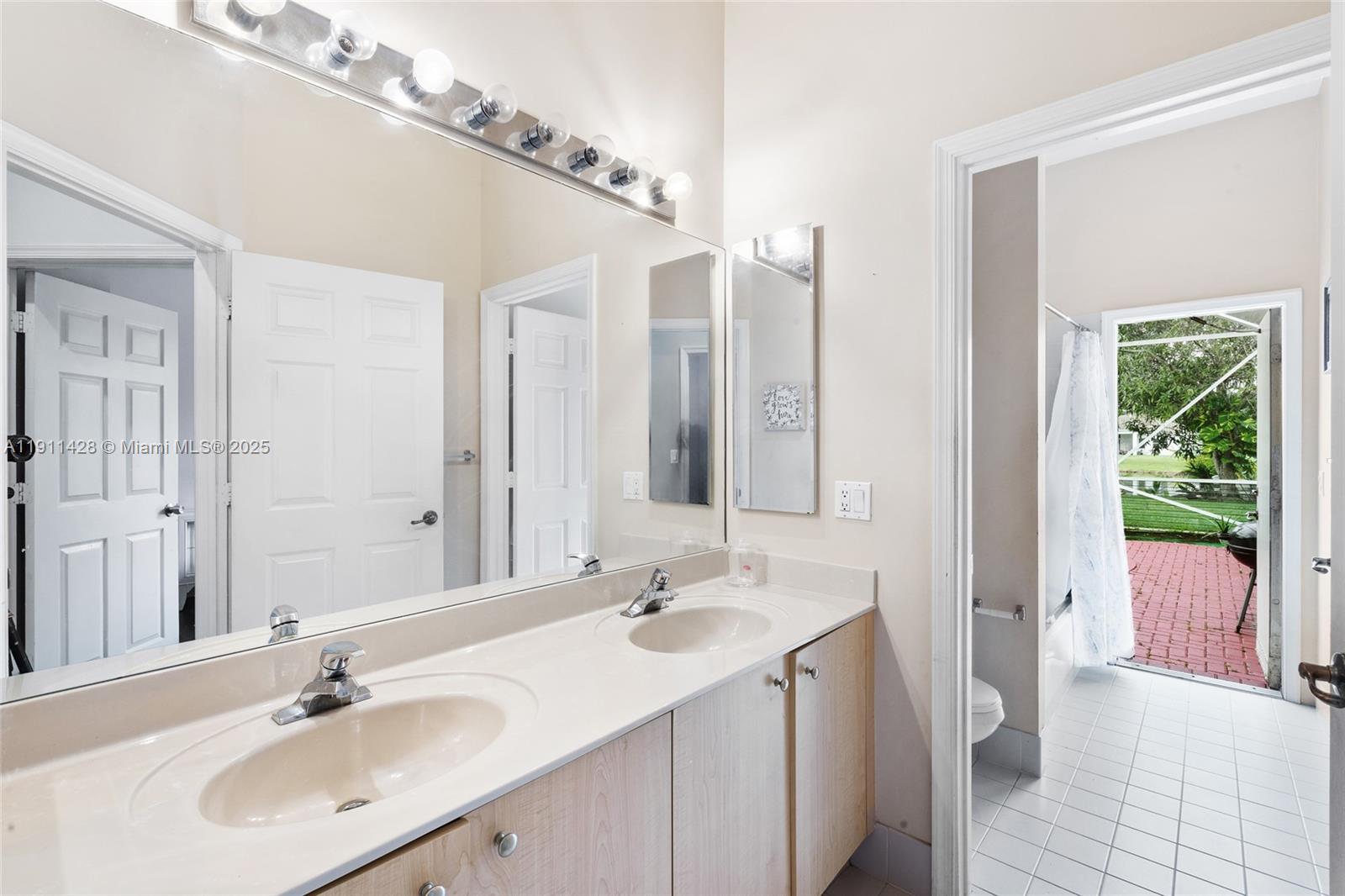 13875 Southwest 41st Street Davie, FL 33330 - Photo 36 of 62 a bathroom with a double vanity sink and a mirror