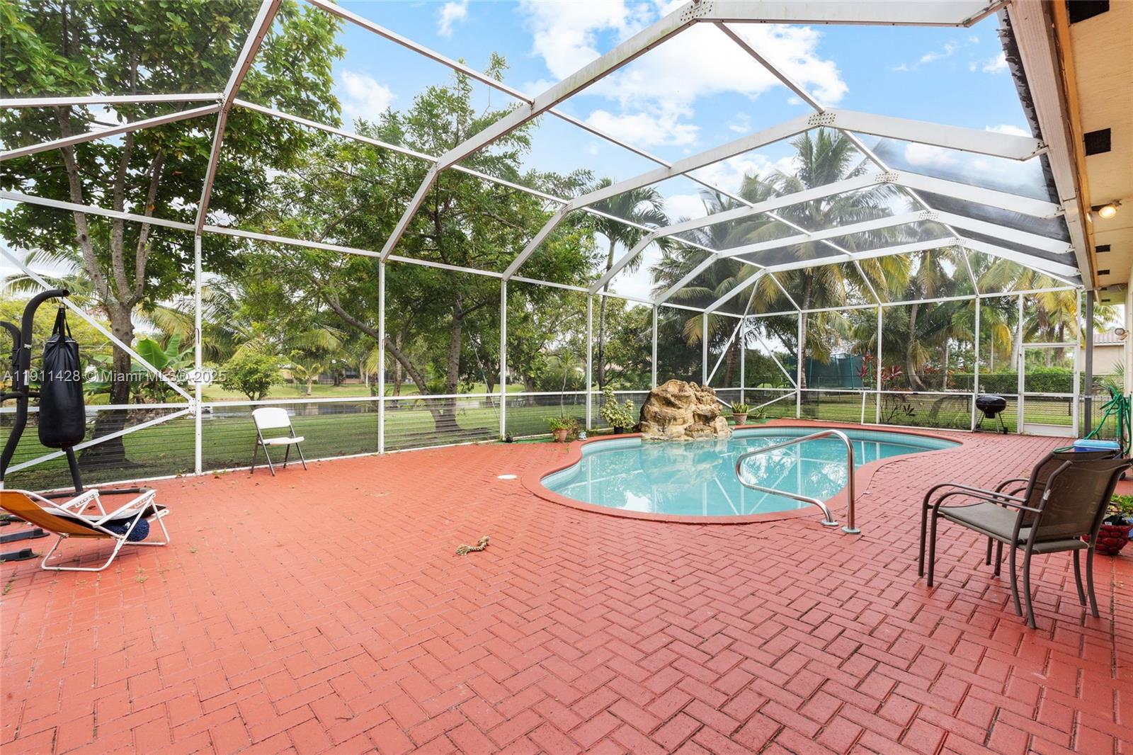 13875 Southwest 41st Street Davie, FL 33330 - Photo 40 of 62 a view of a swimming pool with a patio and a yard
