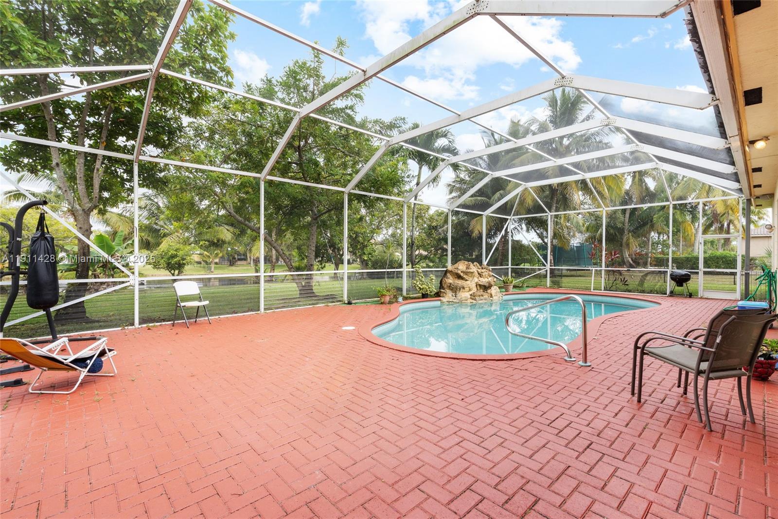 13875 Southwest 41st Street Davie, FL 33330 - Photo 41 of 62 a view of a swimming pool with a patio and a yard