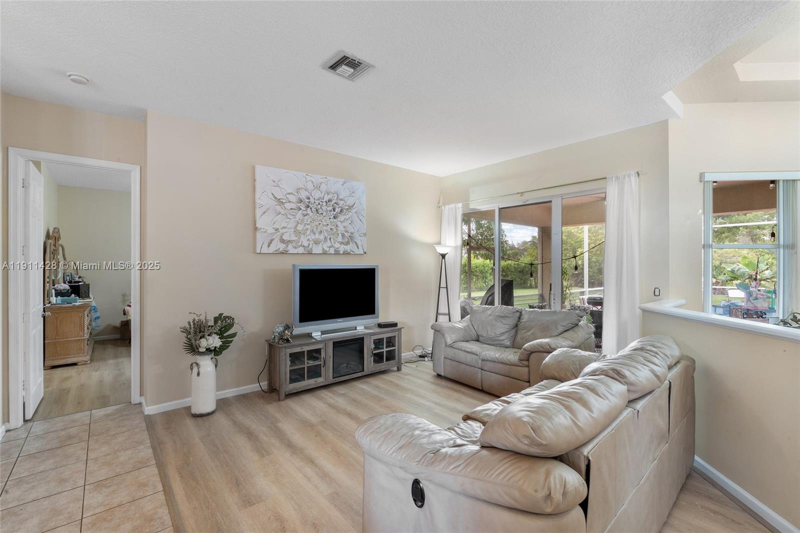 13875 Southwest 41st Street Davie, FL 33330 - Photo 7 of 62 a living room with furniture a flat screen tv and a fireplace