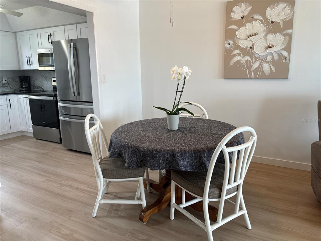 4725 Cove Circle, Unit 405 St. Petersburg, FL 33708 - Photo 7 of 23 a dining room with furniture and wooden floor