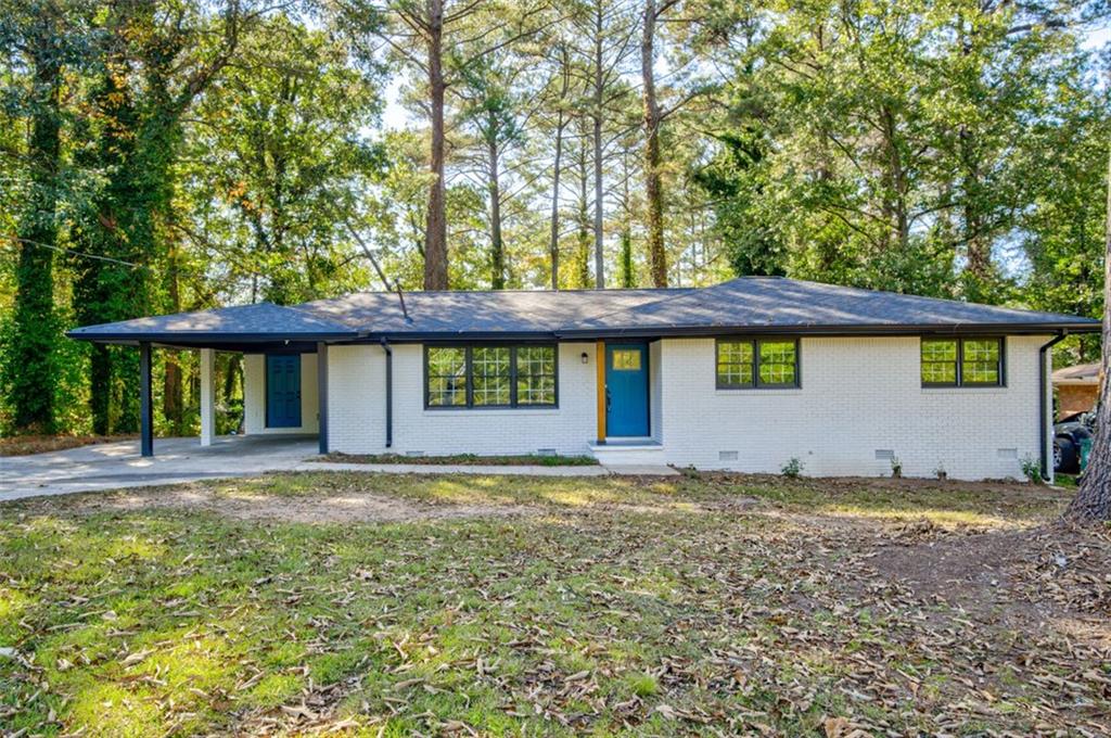 a view of a house with a yard and sitting area