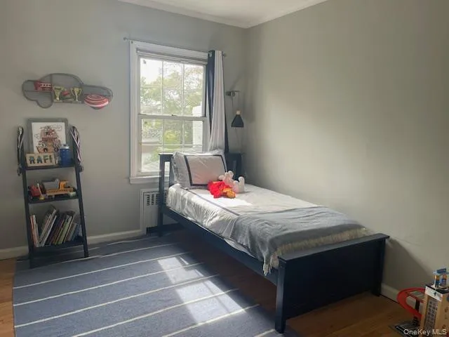 a bedroom with a bed a window and a dresser