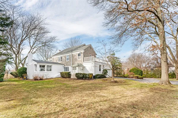 a front view of a house with a yard covered with snow