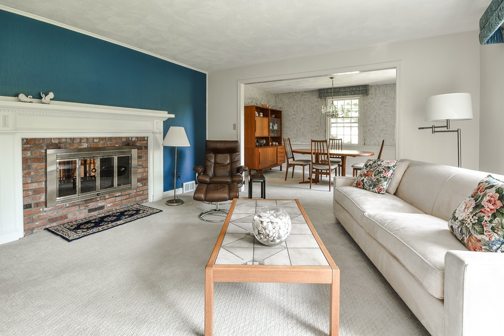 18 Griscom Road Sudbury, MA 01776 - Photo 2 of 29 a living room with furniture a fireplace and potted plants with wooden floor