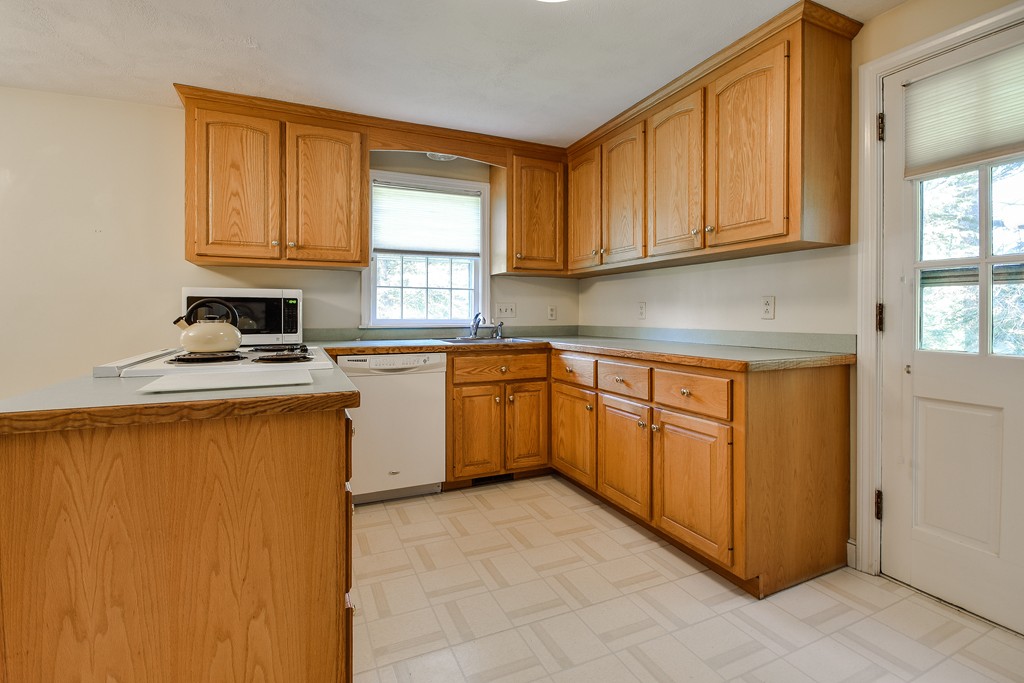 18 Griscom Road Sudbury, MA 01776 - Photo 7 of 29 a kitchen with stainless steel appliances granite countertop a stove a sink a refrigerator with grey cabinets
