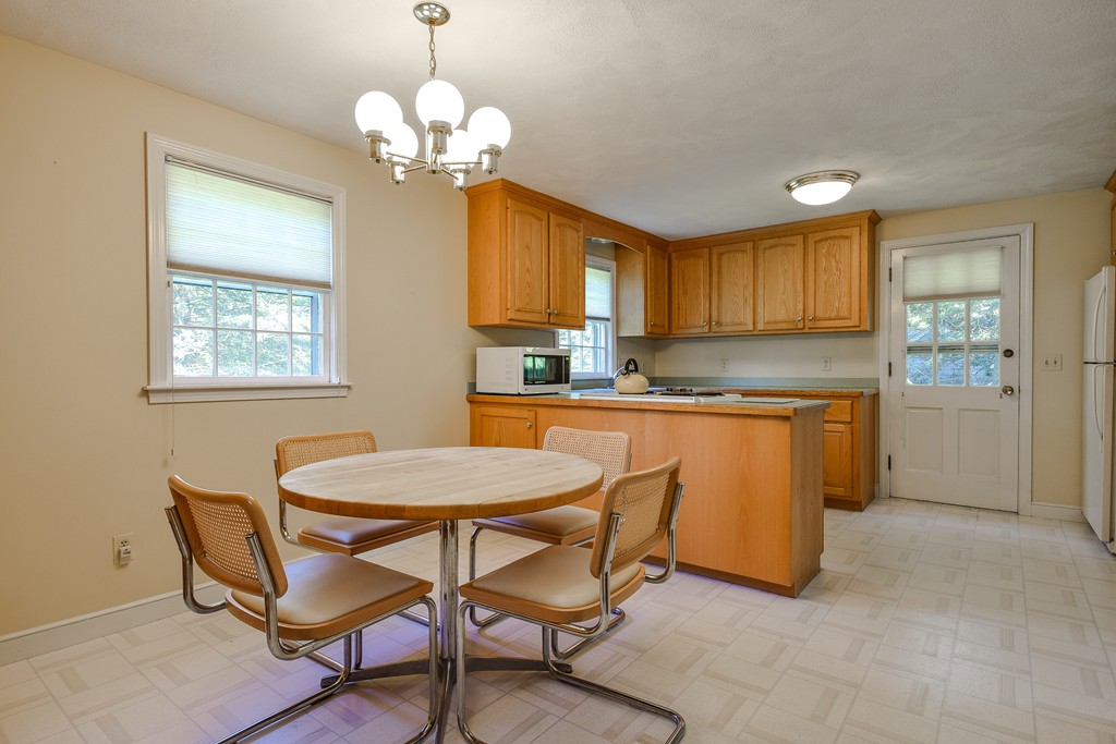 18 Griscom Road Sudbury, MA 01776 - Photo 10 of 29 a kitchen with a dining table chairs and a refrigerator