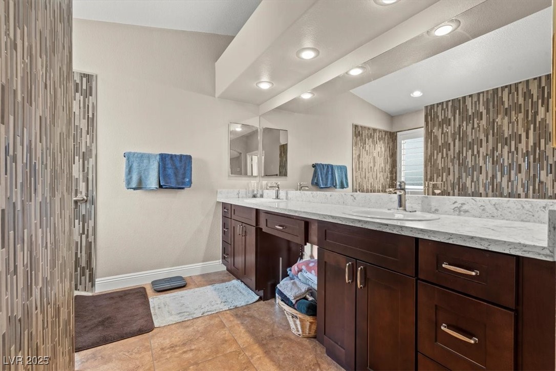 9031 West Viking Road Las Vegas, NV 89147 - Photo 20 of 33 Full bathroom featuring a sink, baseboards, double vanity, and tile patterned flooring