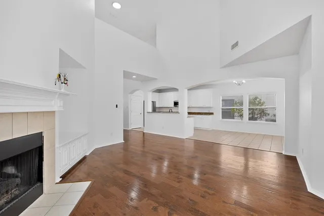 a view of a livingroom with wooden floor and a kitchen