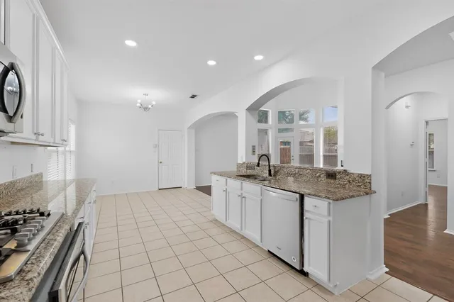 a kitchen with stainless steel appliances granite countertop a stove and a sink