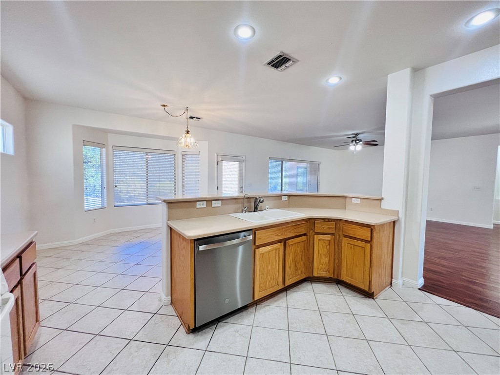 3047 Hickory Valley Road Henderson, NV 89052 - Photo 7 of 33 A functional kitchen with light wood cabinetry and tile flooring, opening to a sun-filled breakfast area.