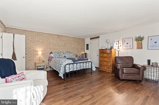 a bed room with a bed a television and dresser