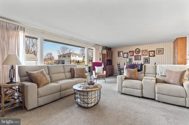 a living room with furniture a fireplace and a window