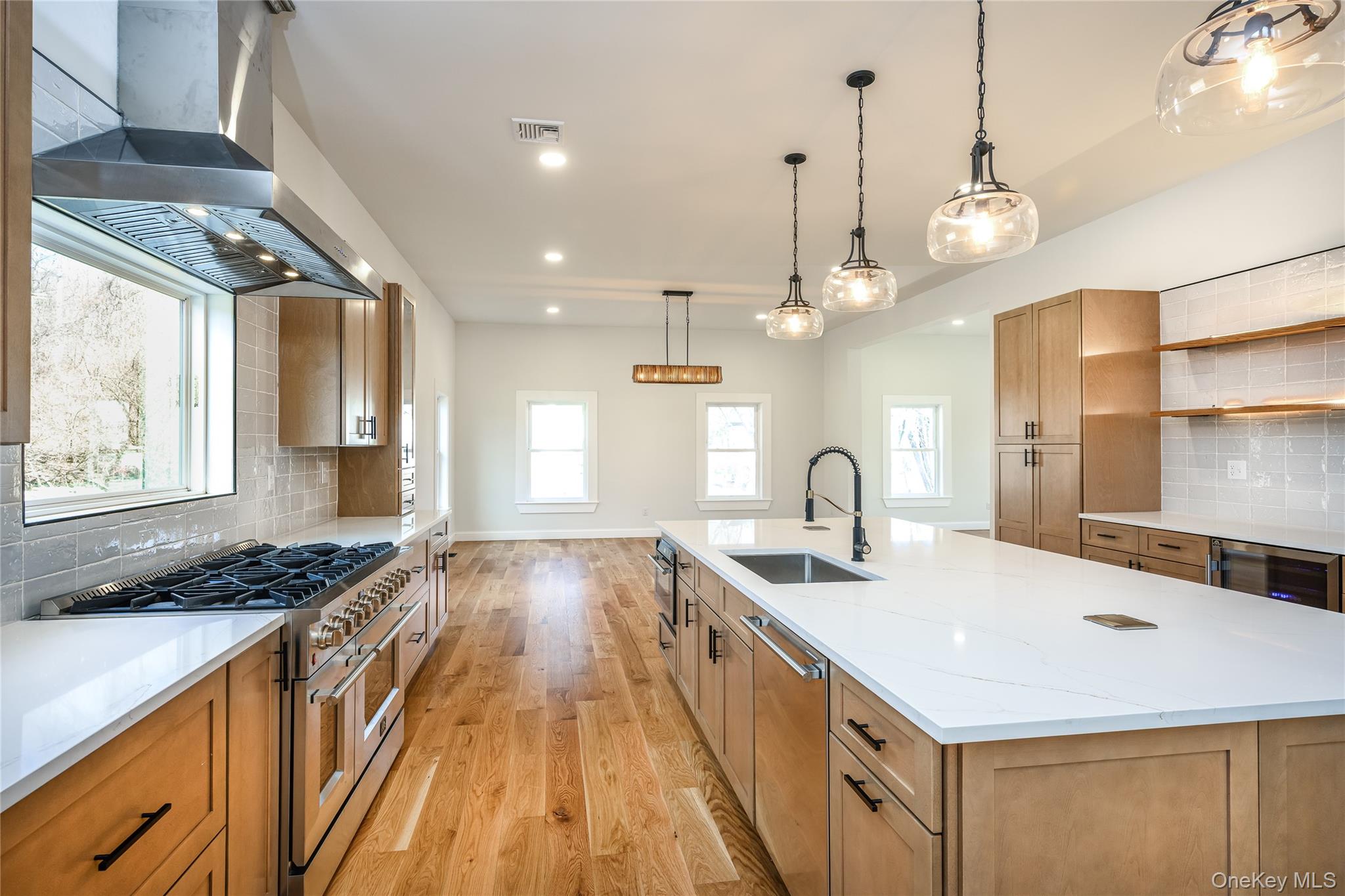 133 West Mombasha Road Monroe, NY 10950 - Photo 11 of 41 a kitchen with kitchen island granite countertop a stove a sink a dining table and chairs with wooden floor