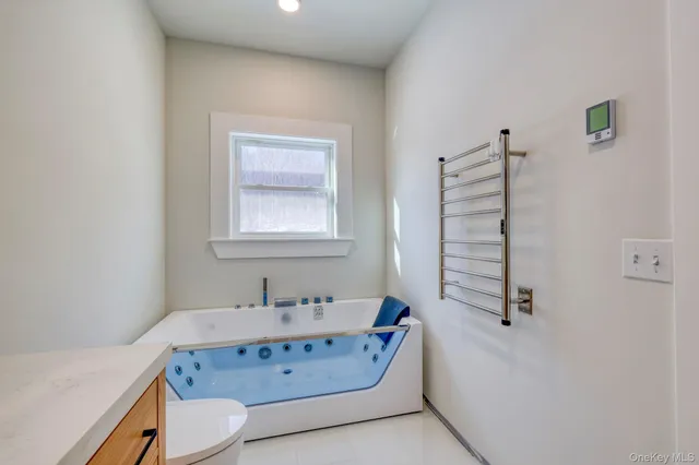 a bathroom with a tub sink and mirror