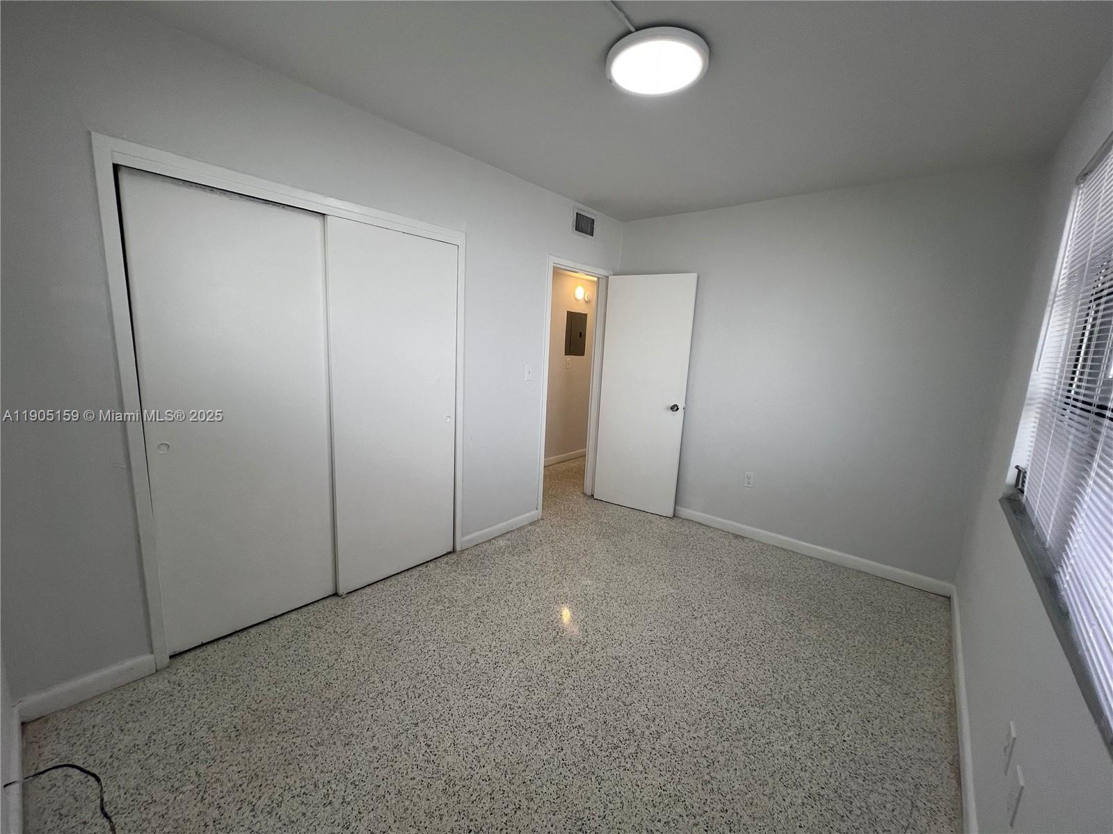 675 Southwest 7th Avenue, Unit 7 Miami, FL 33130 - Photo 12 of 16 an empty room with windows and entrance