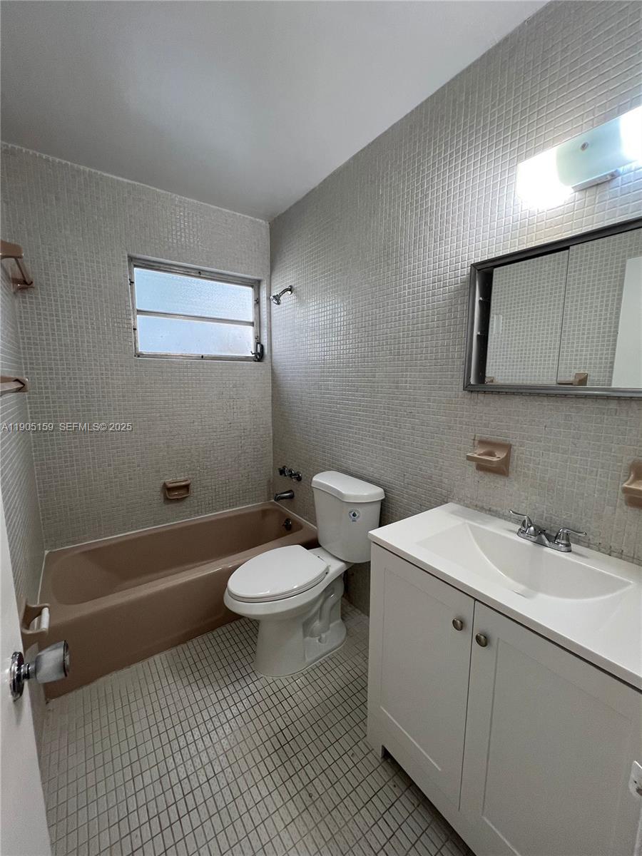 675 Southwest 7th Avenue, Unit 7 Miami, FL 33130 - Photo 13 of 16 a bathroom with a sink a toilet and mirror