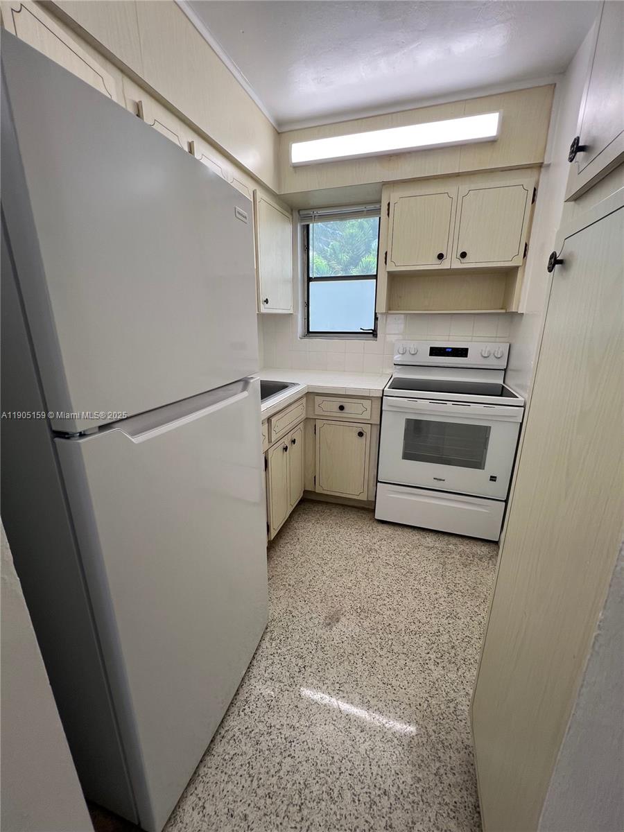 675 Southwest 7th Avenue, Unit 7 Miami, FL 33130 - Photo 5 of 16 a kitchen with white cabinets and white appliances