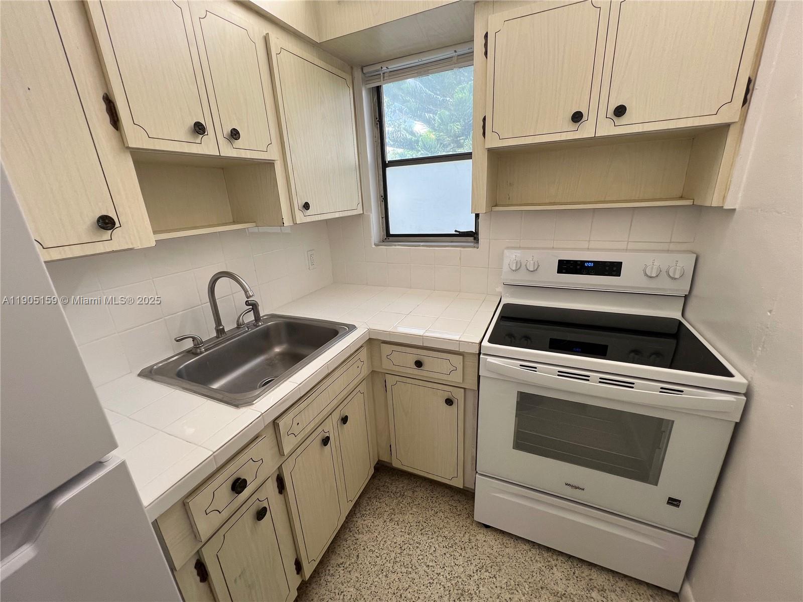 675 Southwest 7th Avenue, Unit 7 Miami, FL 33130 - Photo 8 of 16 a kitchen with white cabinets and white appliances