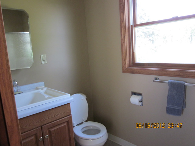18444 University Road Malta, IL 60150 - Photo 19 of 25 a bathroom with a toilet sink and mirror