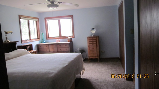 18444 University Road Malta, IL 60150 - Photo 21 of 25 a bedroom with a bed and a chandelier