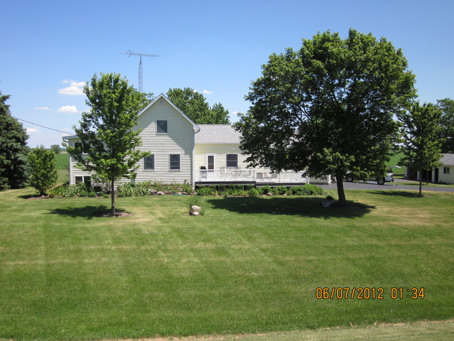 18444 University Road Malta, IL 60150 - Photo 22 of 25 a front view of a house with garden