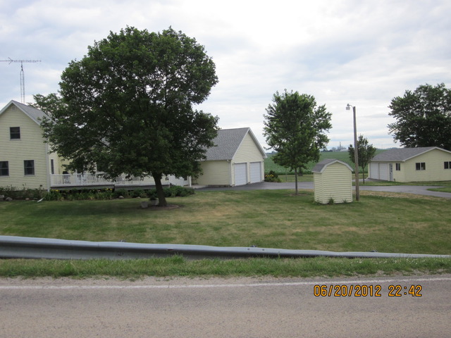 18444 University Road Malta, IL 60150 - Photo 23 of 25 a front view of a house with a garden and trees
