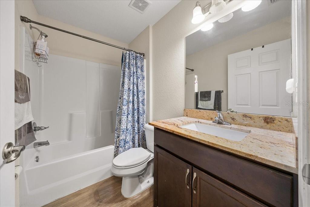 19 Juniper Loop Run Ocala, FL 34480 - Photo 18 of 42 a bathroom with a granite countertop sink a toilet a mirror a bathtub and shower