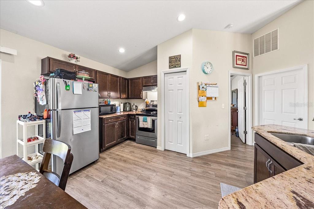 19 Juniper Loop Run Ocala, FL 34480 - Photo 7 of 42 a kitchen with a refrigerator a stove top oven a refrigerator and cabinets
