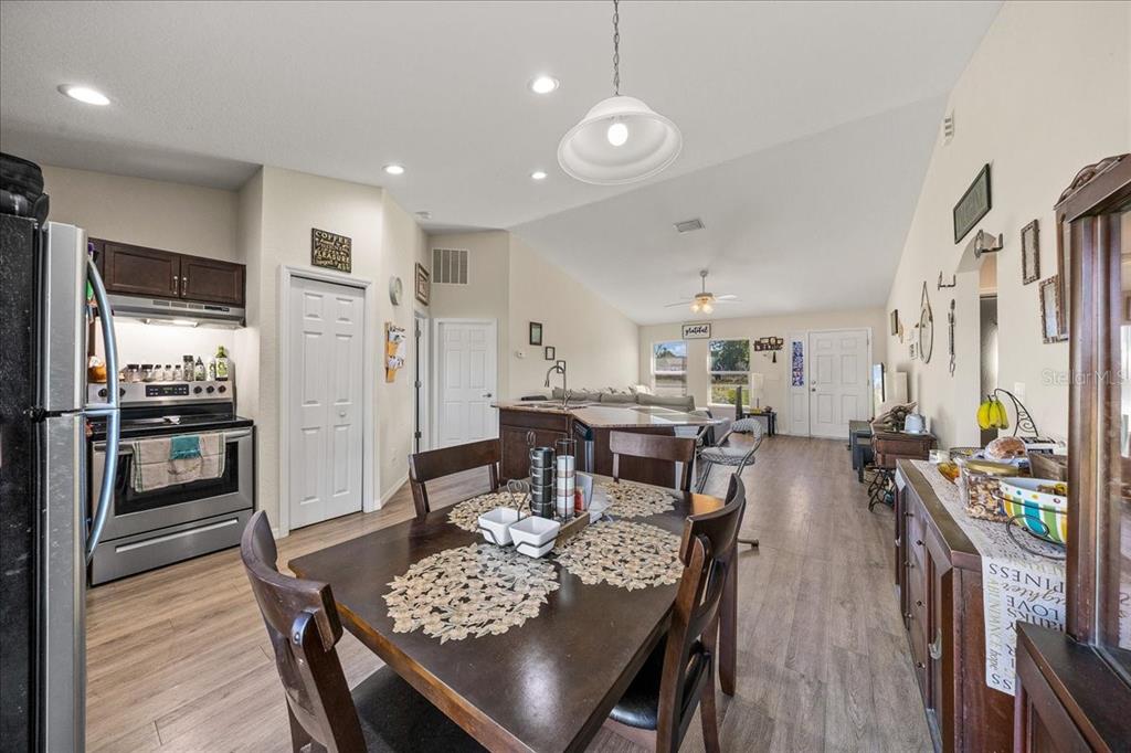 19 Juniper Loop Run Ocala, FL 34480 - Photo 9 of 42 a view of a dining room and livingroom with furniture wooden floor a rug a fireplace and a chandelier