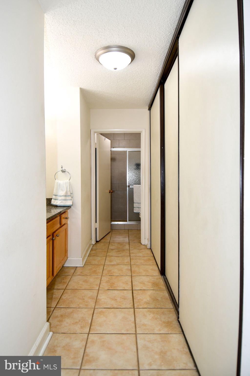 3500 Forest Edge Drive, Unit 152E Silver Spring, MD 20906 - Photo 11 of 33 a hallway with a bathroom and a mirror