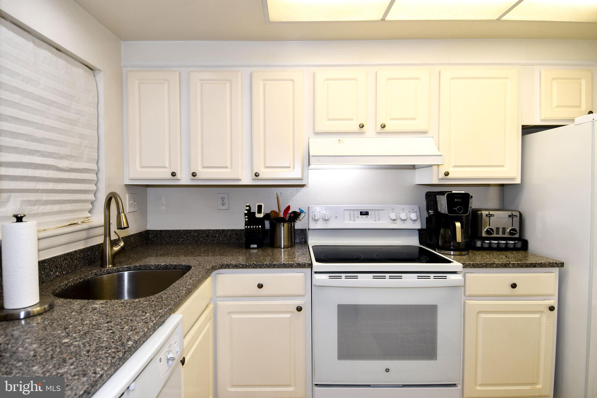 3500 Forest Edge Drive, Unit 152E Silver Spring, MD 20906 - Photo 2 of 33 a kitchen with a stove a sink and a microwave