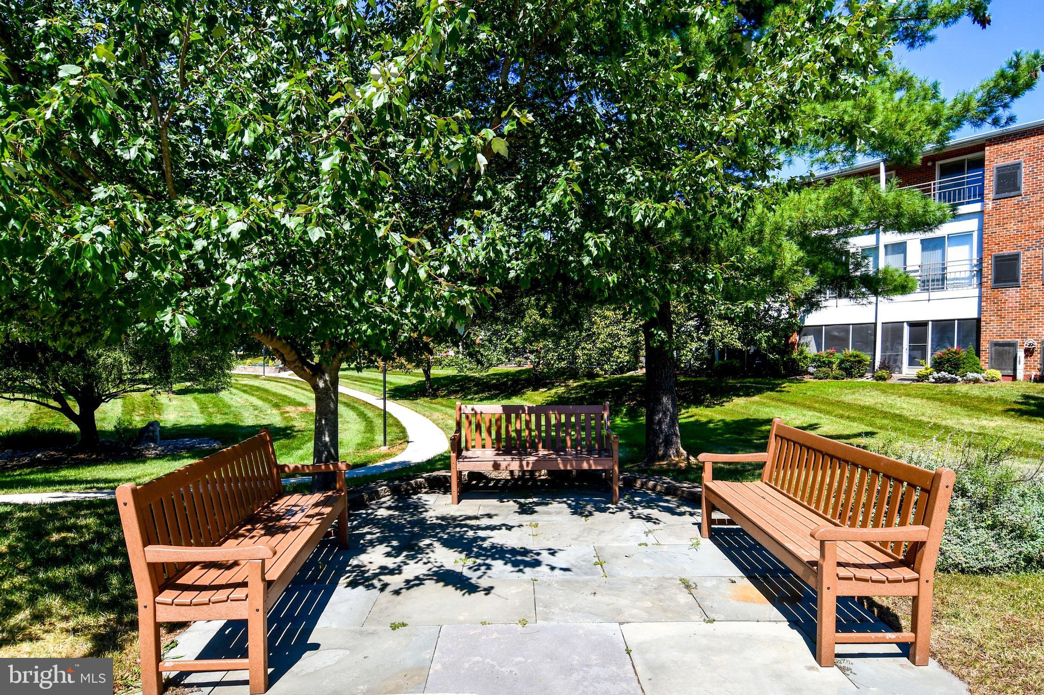 3500 Forest Edge Drive, Unit 152E Silver Spring, MD 20906 - Photo 26 of 33 a view of a patio with table and chairs and a large tree