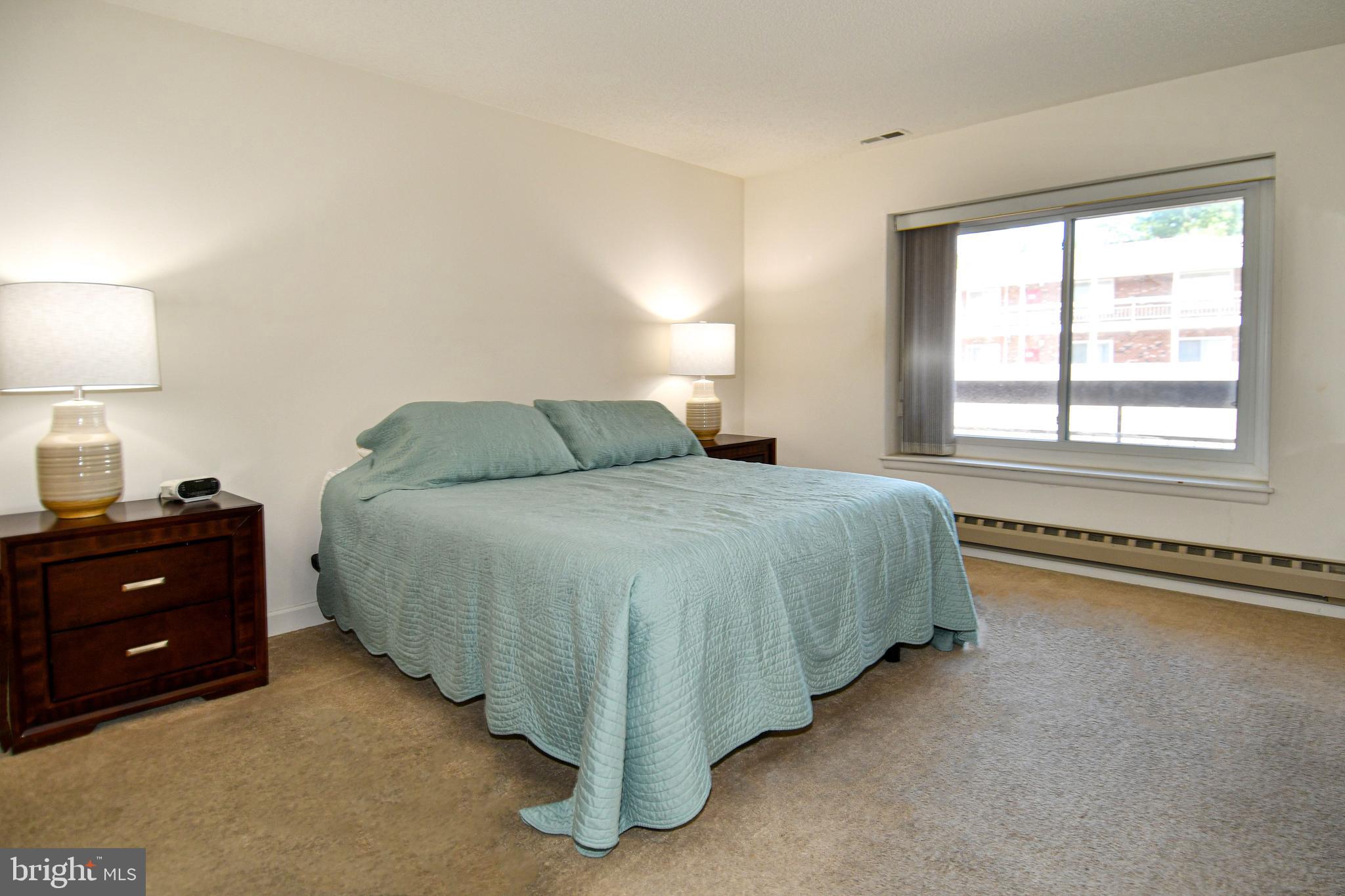 3500 Forest Edge Drive, Unit 152E Silver Spring, MD 20906 - Photo 9 of 33 a bedroom with a bed and a lamp