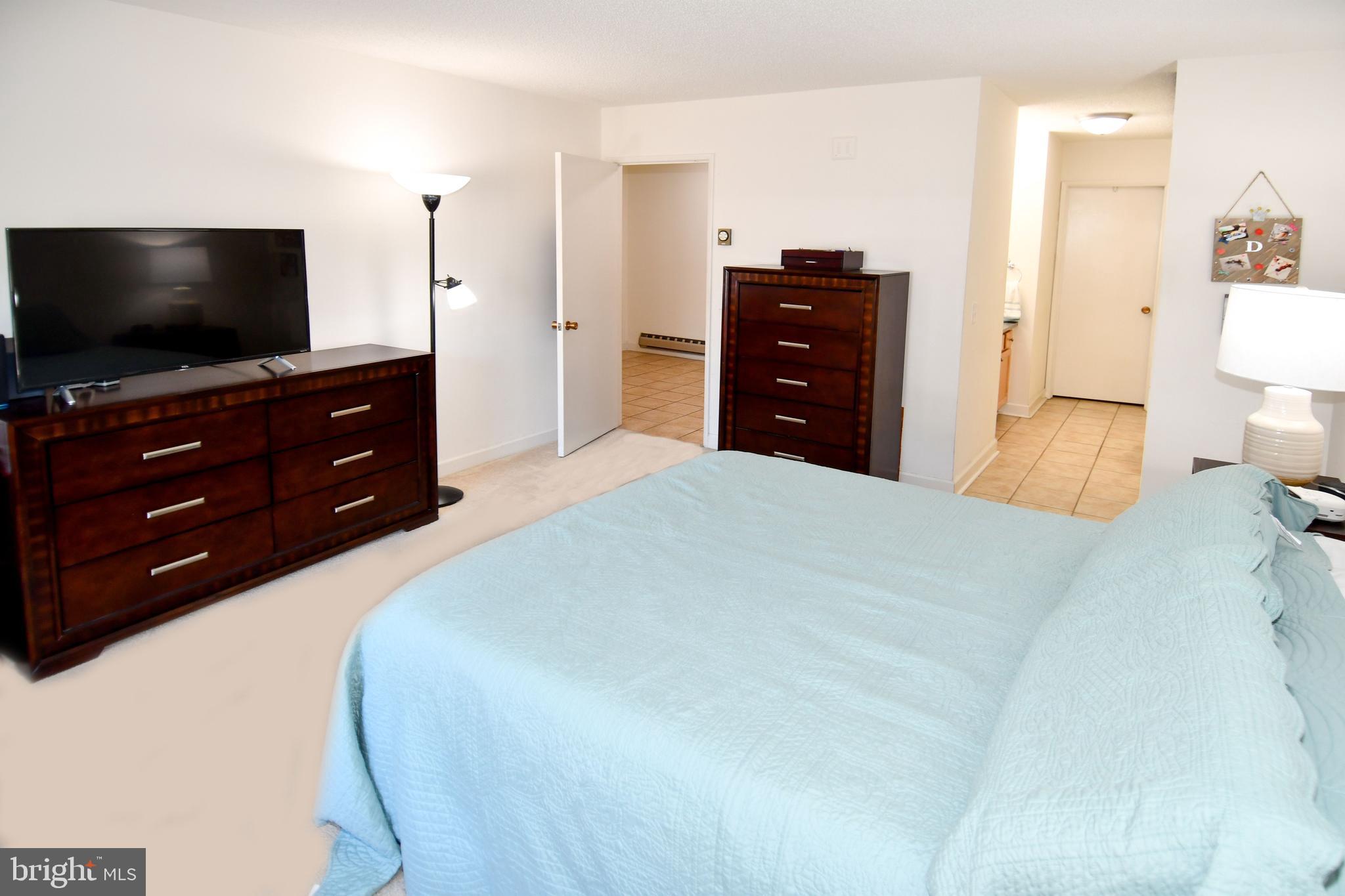 3500 Forest Edge Drive, Unit 152E Silver Spring, MD 20906 - Photo 10 of 33 a bedroom with a bed and a flat screen tv