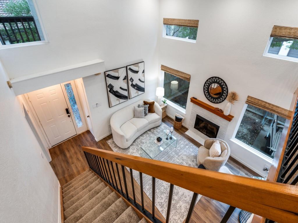 18040 Midway Road, Unit 189 Dallas, TX 75287 - Photo 12 of 28 Living area featuring stairway, a towering ceiling, healthy amount of natural light, wood finished floors, and a fireplace