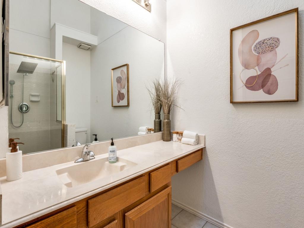 18040 Midway Road, Unit 189 Dallas, TX 75287 - Photo 18 of 28 Bathroom with vanity, a stall shower, a textured wall, and light tile patterned flooring