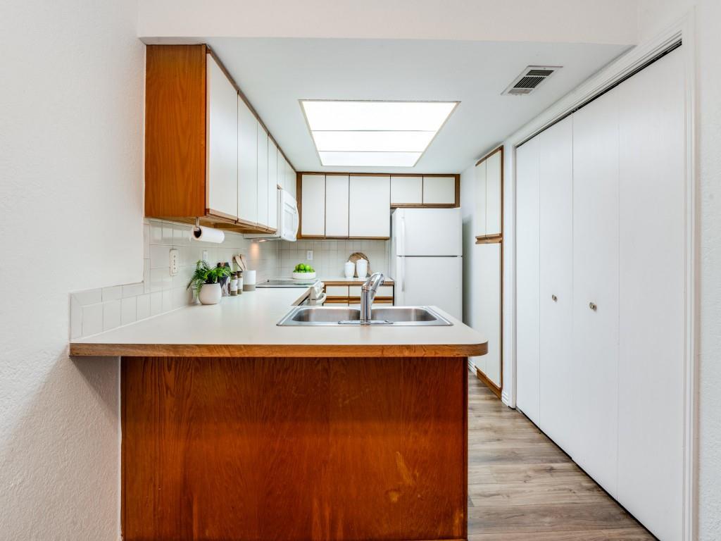 18040 Midway Road, Unit 189 Dallas, TX 75287 - Photo 8 of 28 Kitchen featuring a peninsula, light countertops, white cabinetry, and brown cabinetry