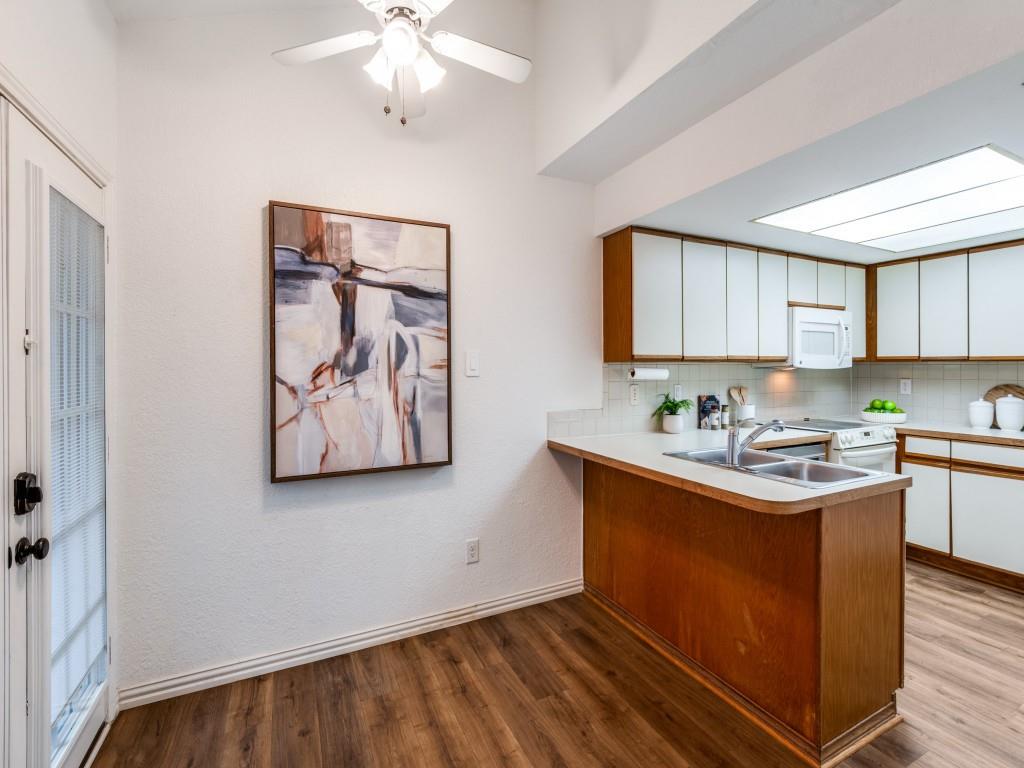 18040 Midway Road, Unit 189 Dallas, TX 75287 - Photo 9 of 28 Kitchen featuring white cabinets, brown cabinets, a peninsula, light countertops, and a textured wall