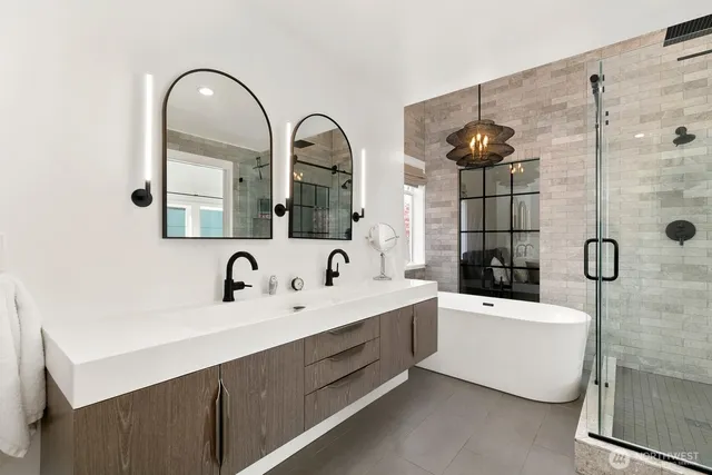 a en suite bathroom with a double vanity sink a mirror and a bathtub