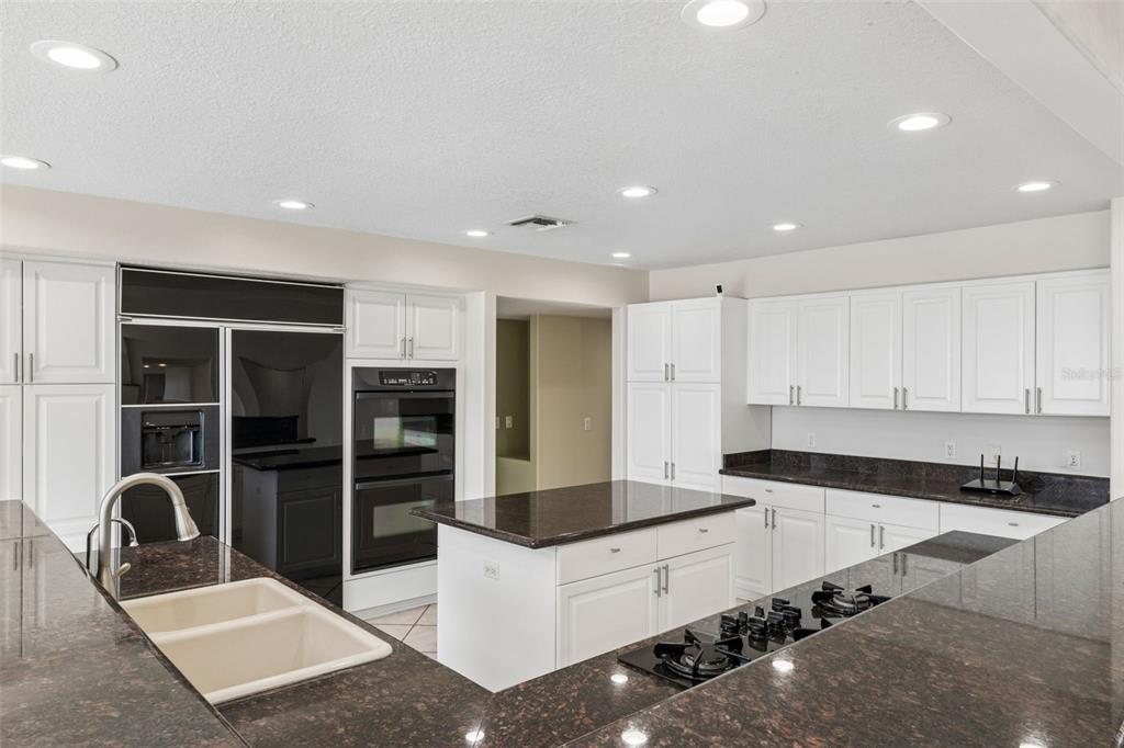 4301 Down Point Lane Windermere, FL 34786 - Photo 24 of 61 a living room with stainless steel appliances kitchen island granite countertop a refrigerator a stove a sink and white cabinets with wooden floor