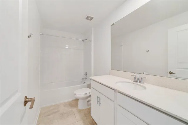 a bathroom with a granite countertop sink a toilet and bathtub