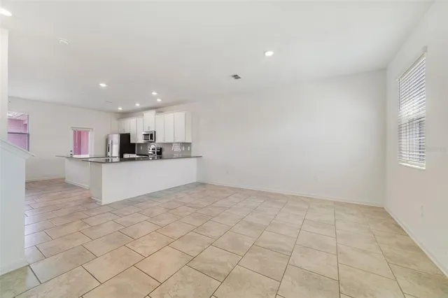 a kitchen with stainless steel appliances granite countertop a sink a stove a refrigerator a microwave and cabinets