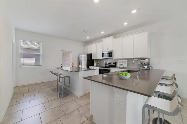 a kitchen with stainless steel appliances granite countertop a sink refrigerator and stove